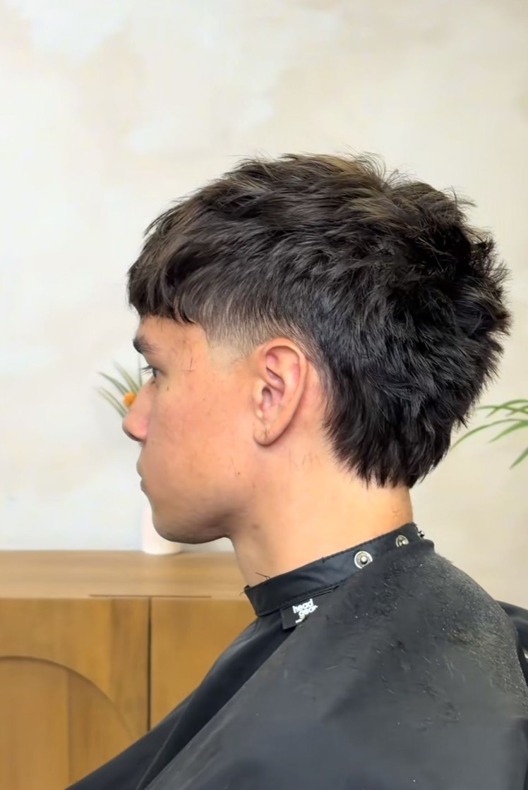 Mullet texturizado a tijera, nuca larga y patilla marcada